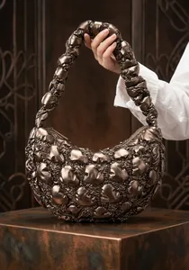Detail of metallic bronze quilted hobo bag featuring ruched cloud-style shoulder strap