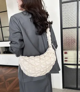 Detail of cream puffy hobo bag with heart-shaped quilted pattern and soft texture