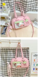 Détail d'un sac Ita rose avec fenêtres PVC transparentes, peluches et nœuds en dentelle