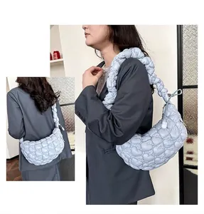 Detail of light blue heart-quilted crossbody bag showing puffy texture and stitching