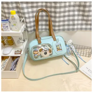 Détail du sac bleu clair avec fenêtre transparente, poupée en peluche et nœud en dentelle