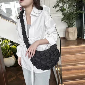 Chic black heart-quilted cloud shoulder bag with pleated strap in minimalist setting