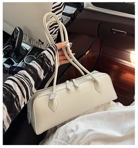 Detail of off-white rectangle handbag with dual zippers and long shoulder straps