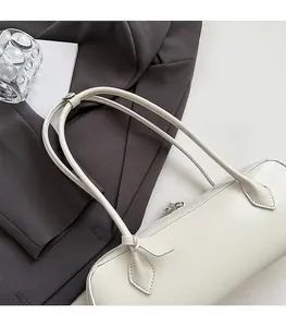 Detail of the comfortable long strap and smooth leather texture on this cream baguette bag