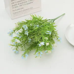 Close-up of faux jasmine and daisy bouquet with blue and white petals and green leaves