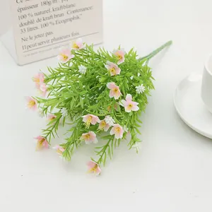 Detail of pink and white silk jasmine bouquet in a ceramic dish on white table