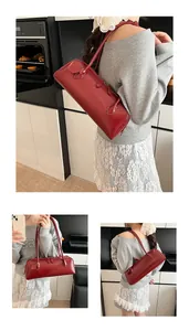 Detail view of burgundy leather baguette bag showing long handles and slim silhouette