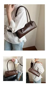 Detail view showing long brown PU leather baguette bag with dual slim shoulder straps