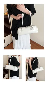 Detail view of a long rectangular cream underarm bag with sleek zipper and leather texture