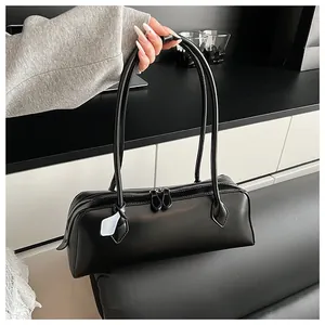 Detail of vintage black elongated Boston baguette bag with long handles and smooth leather