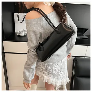 Detail view of a black rectangular baguette shoulder bag with matte leather finish
