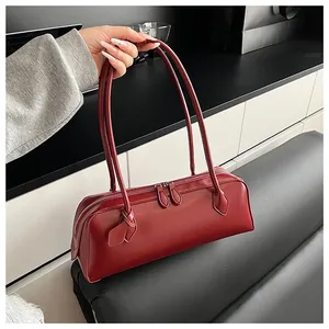 Detail view of burgundy long baguette bag featuring dual zippers and slim shoulder straps