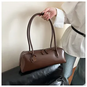 Detail view of smooth chocolate leather finish and dual zipper of the long baguette bag