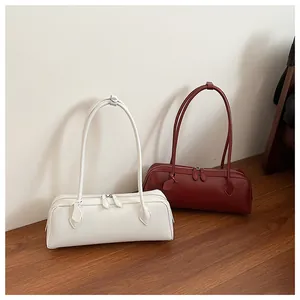 Detail view of white and dark red rectangular baguette bags with double zippers