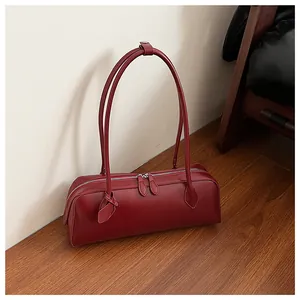 Macro detail of dark red leather Boston bag showing dual metal zippers and textures