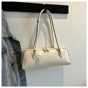 Detail of off-white leather baguette bag with dual zippers and long shoulder straps