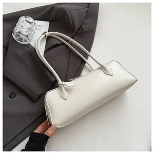 Close-up of minimalist white leather baguette bag with dual slim shoulder straps