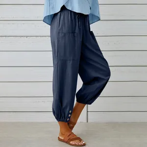Dettaglio dei pantaloni larghi in cotone e lino blu navy con bottoni laterali sul fondo