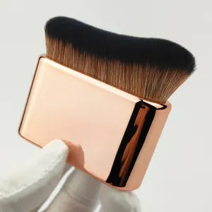 Detailed close-up of a wide body tanning brush with elegant rose gold handle finish.
