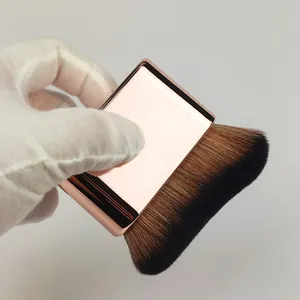 Close-up view of a professional rose gold flat body brush with dense soft bristles