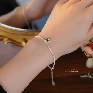 Detail of S925 silver bracelet featuring sparkling green zircon and twisted chain texture