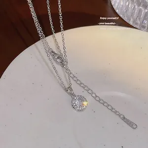 Gros plan détaillé d'un pendentif en zircon rond étincelant sur une chaîne en argent