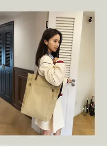 Fashionable large khaki canvas tote bag carried by an Asian woman in a modern room