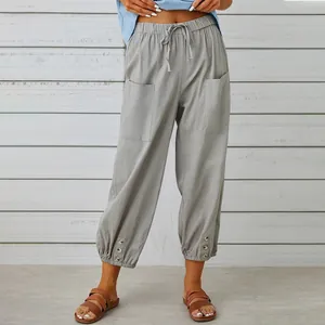 Pantaloni in cotone e lino grigi che mostrano vita alta, tasche e orlo con bottoni