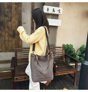 Vintage gray canvas tote bag shown as a detailed view on an Asian female model outdoors
