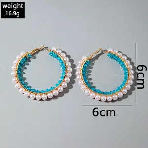 Vista dettagliata di orecchini a cerchio da 6cm con perle bianche e cristalli blu