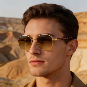 Close-up of stylish oval sunglasses for men with gold frames and gradient lenses