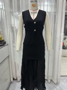 Close-up detail of black knitted vest with gold buttons and matching long skirt