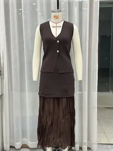 Close-up view of a dark brown knit vest with gold buttons and matching pleated skirt