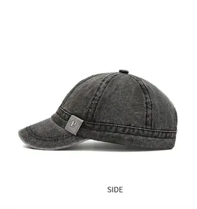Detailed side profile of a washed canvas short brim baseball cap in dark grey finish