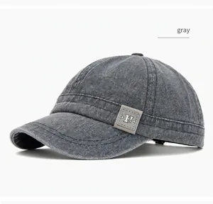 Close-up of the washed canvas texture and short brim on a gray vintage baseball cap