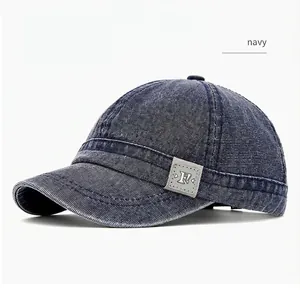 Macro detail view of a navy blue washed canvas short brim baseball cap with patch