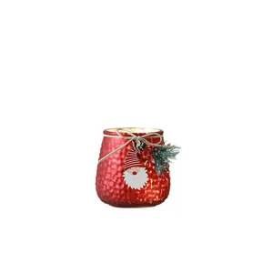 Festive red textured glass Christmas candle holder with Santa Claus motif and warm glow