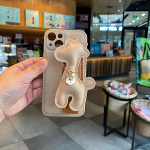 Detailed view of cartoon giraffe phone case with beige leather texture and wrist strap