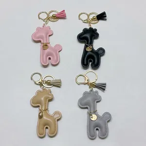Four colorful giraffe PU leather keychains with matching tassels and gold clasps.