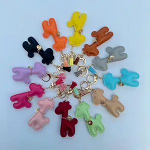 A collection of colorful leather giraffe bag charms with tassels and metal clips