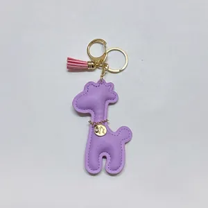 Detail of purple PU leather giraffe keychain with pink tassel and gold charm