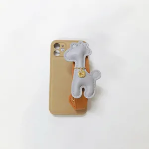 Detailed view of a grey cartoon giraffe charm with orange wrist strap on a phone case