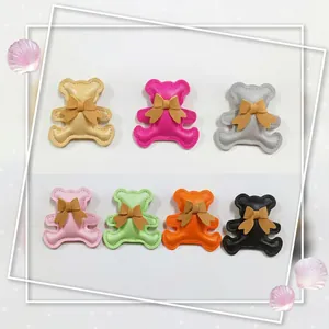 Detailed view of padded PU leather bear patches with bows in multiple colors