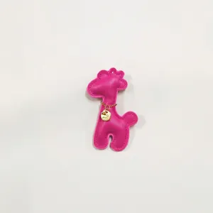 Detailed close-up of a cute pink faux leather giraffe charm for phone cases and bags.