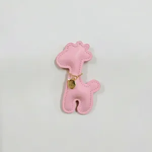 Detailed close-up of a cute pink leather giraffe charm featuring a delicate gold chain