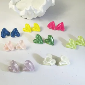 Colorful collection of candy-colored heart-shaped resin stud earrings on a white surface