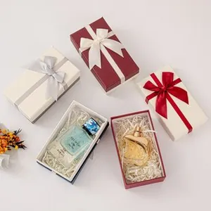 Close-up detail of elegant jewelry gift boxes featuring satin bows and raffia fill