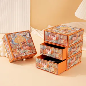 Detail view of orange jewelry storage box with artistic jungle illustrations and pearl handles.