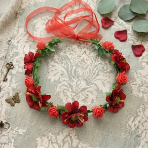 Detailed view of bohemian red flower crown headband with green leaves and red ribbon
