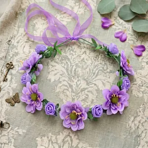 Close-up of bohemian purple floral crown with delicate fabric petals and green leaves